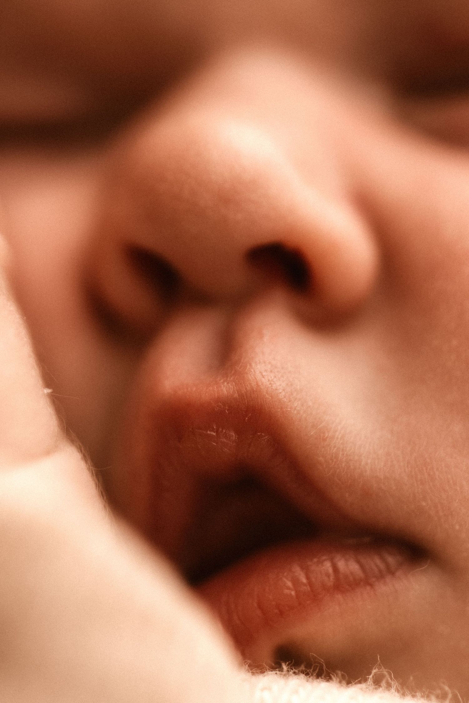 Close-up soft focus macro photo in Denia showing nose and lips with warm sepia toning effect- Denia newborn photographer