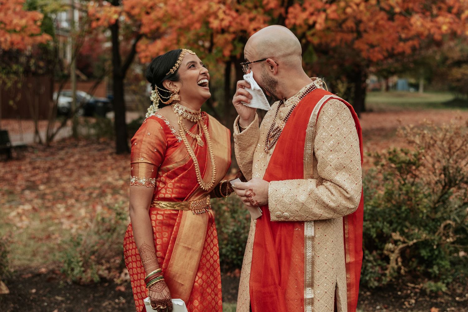 Traditional South Indian bridal jewelry including ornate gold headpiece and necklaces worn with orange and gold saree.