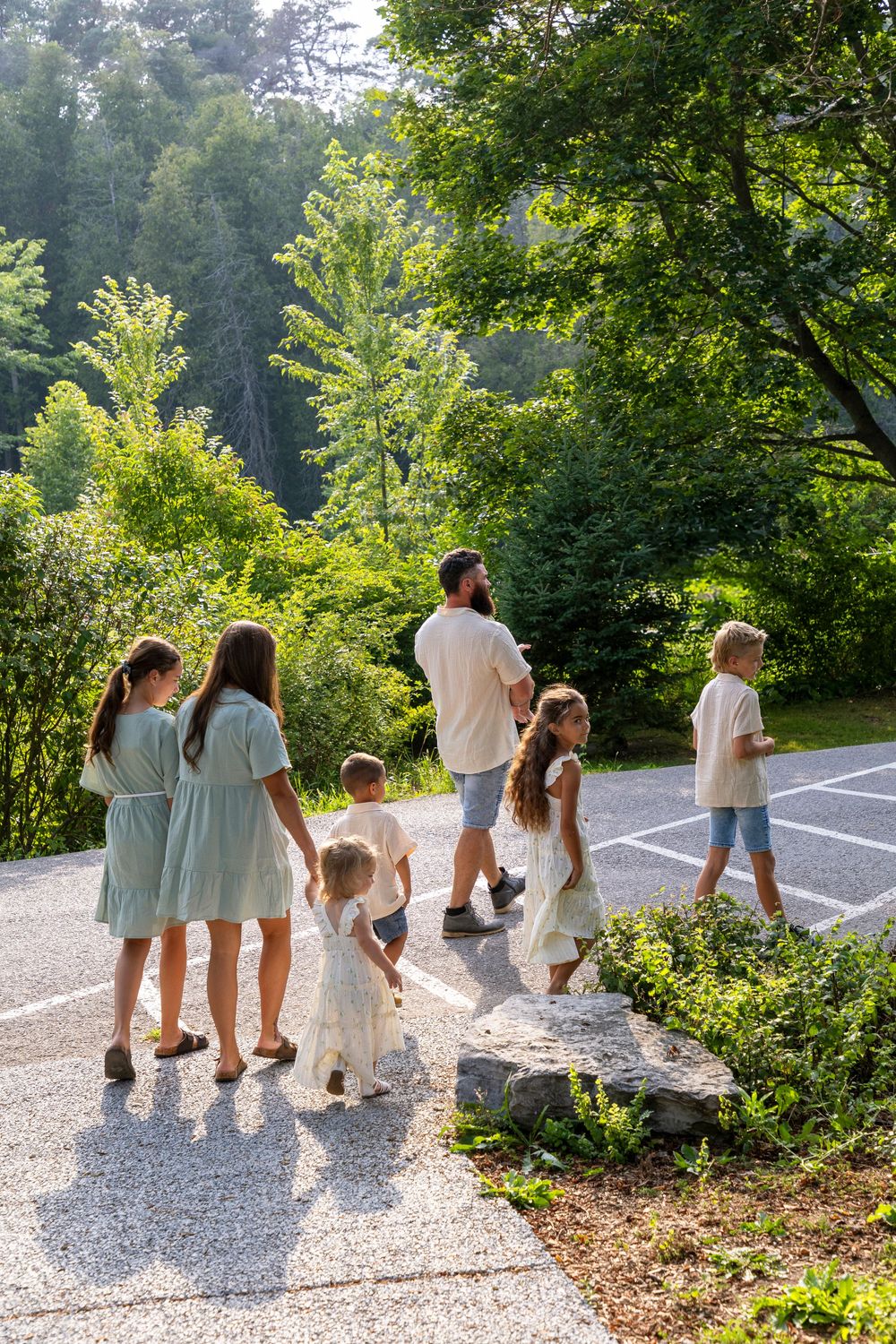A family of 8 walking through a park on a beautiful late summer evening