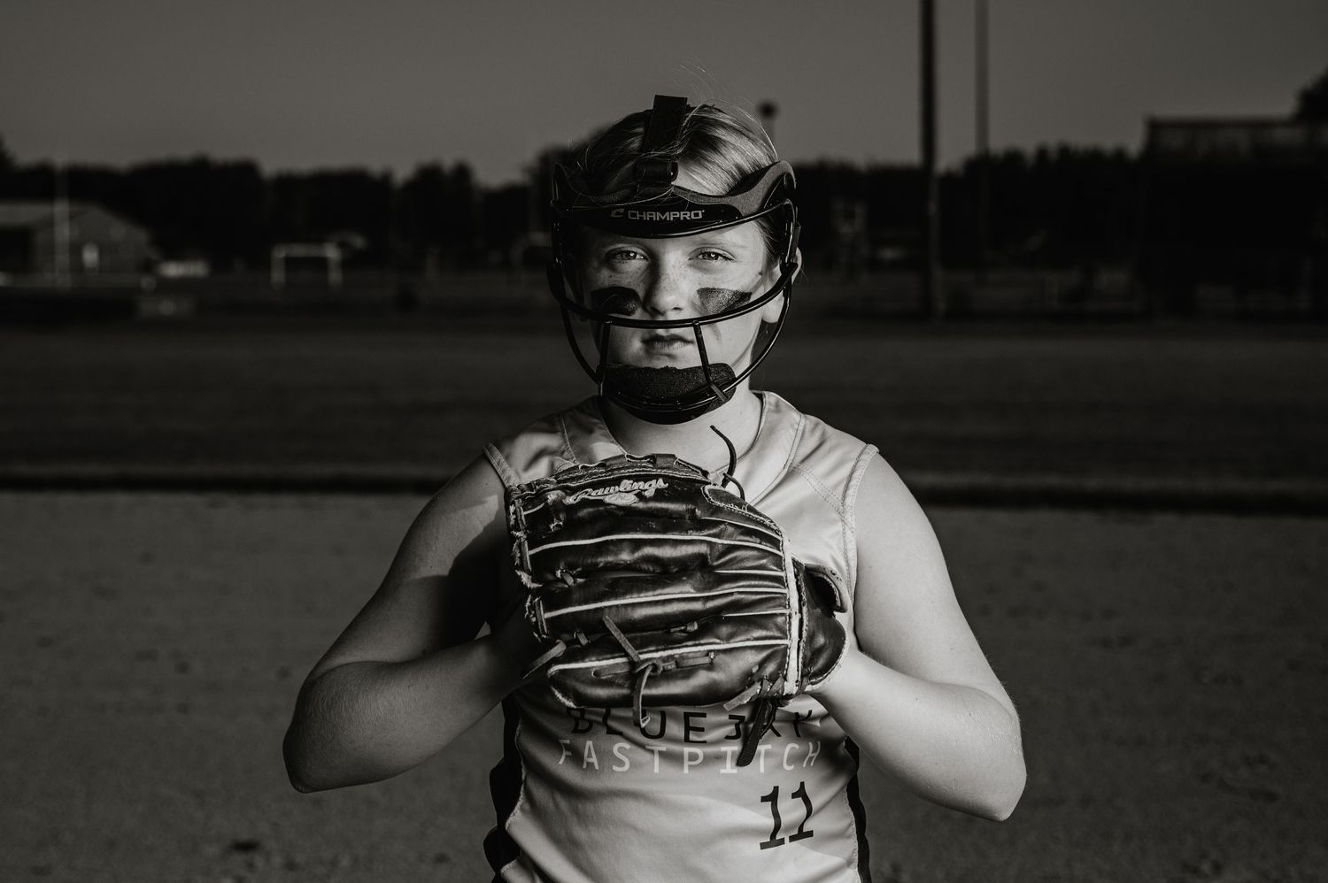 A black and white sequence of softball player catching and framing a pitch behind the plate during a game.