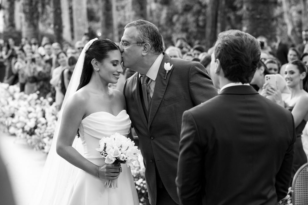 A tender black and white wedding moment captured during an outdoor ceremony.