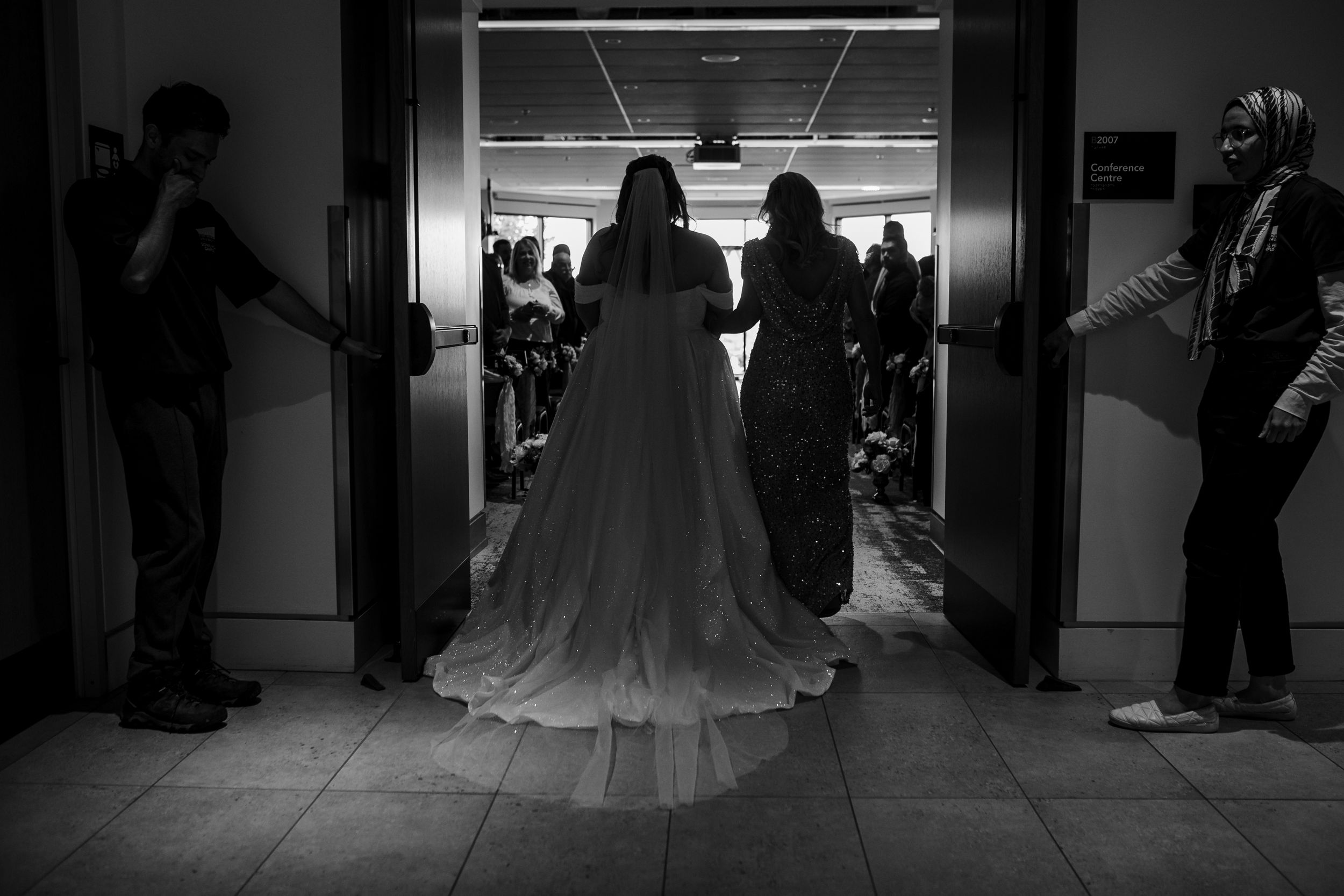 Black and white photos of a bride and wedding party walking down a hallway at different moments of a ceremony.