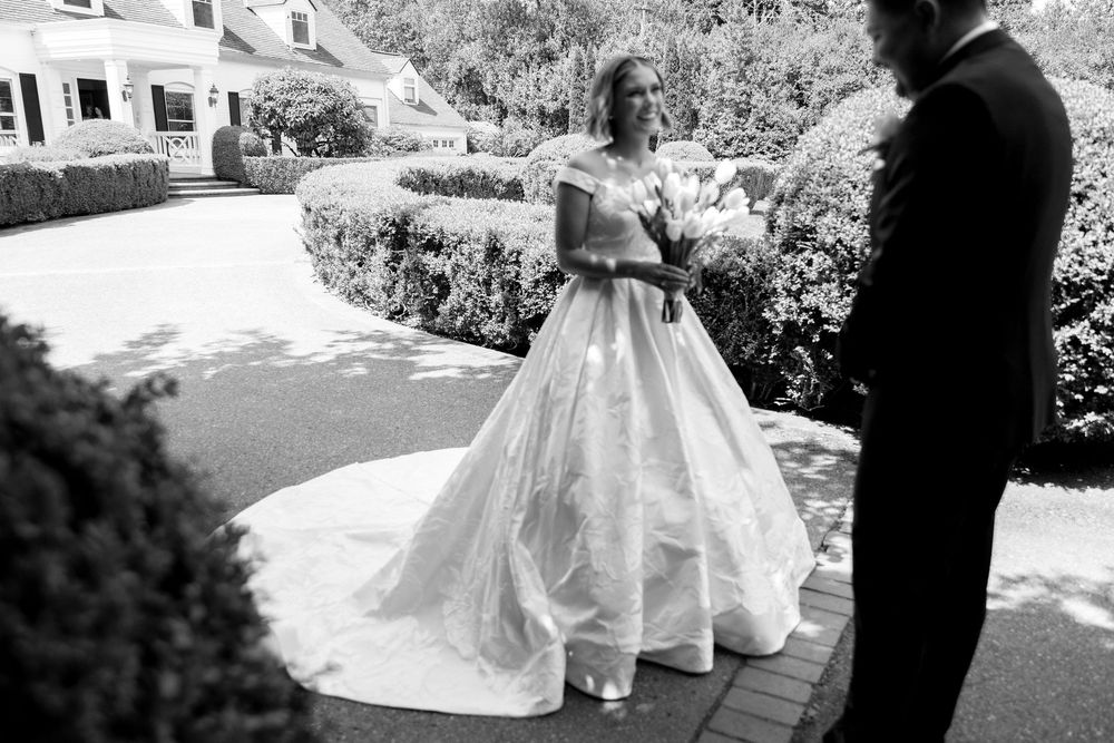 Black and white wedding photo sequence showing bride and groom walking together through an outdoor garden setting.