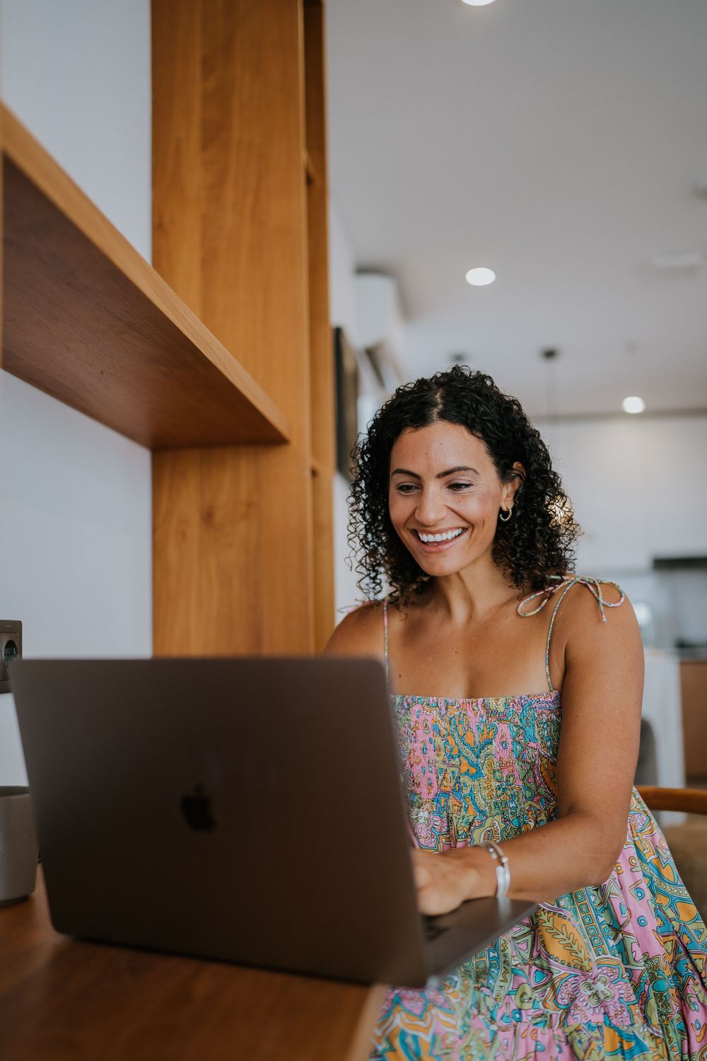 Candid working moments captured at a wooden desk with a laptop in a modern home office setting.