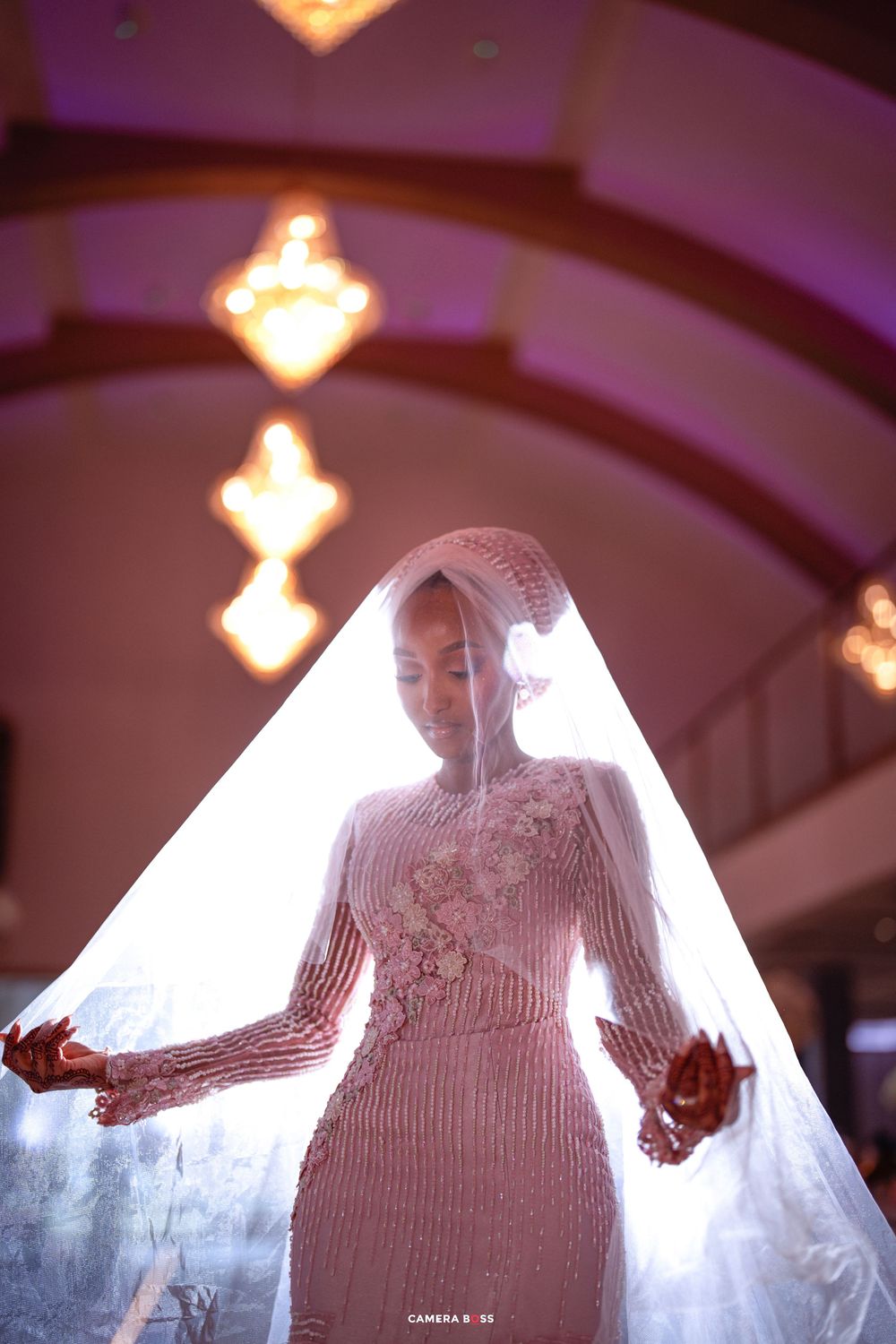 Silhouetted figure backlit in dramatic lighting with glowing effects and flowing fabric creates ethereal artistic performance.