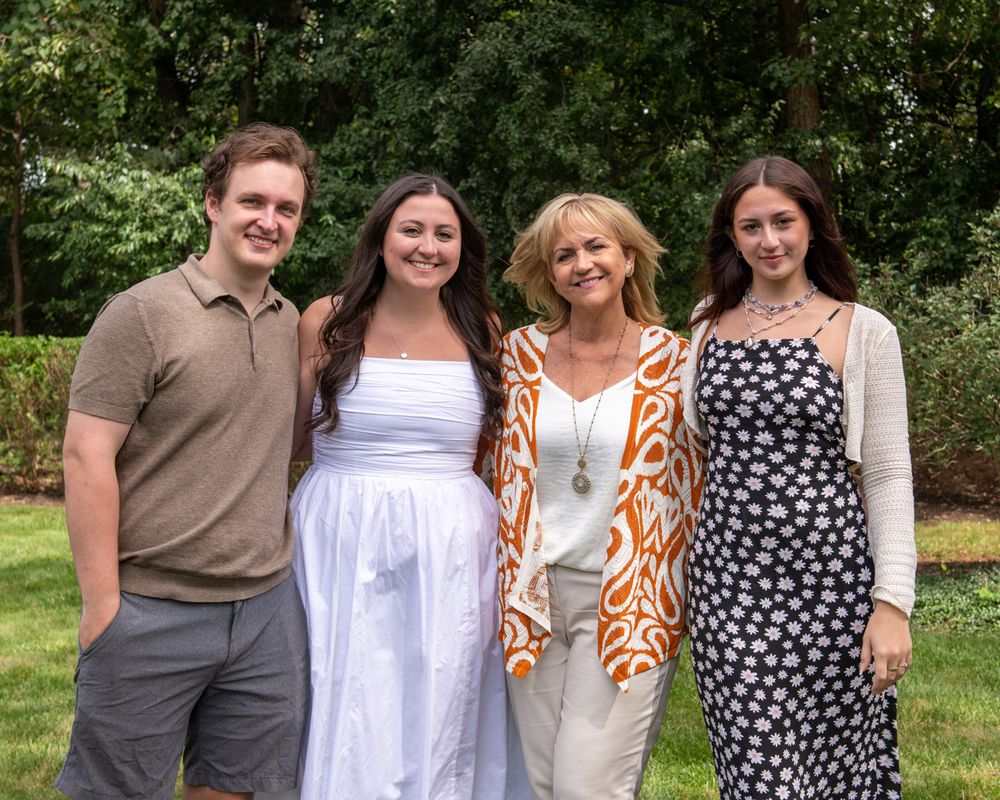 Group of four poses together at outdoor summer gathering.