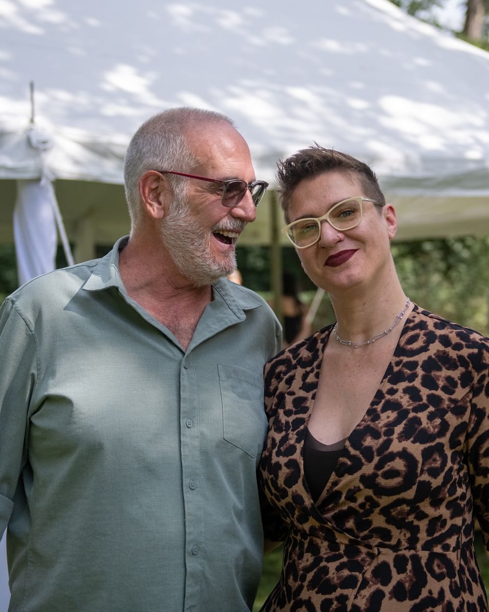 Two guests share a candid moment during outdoor summer celebration.