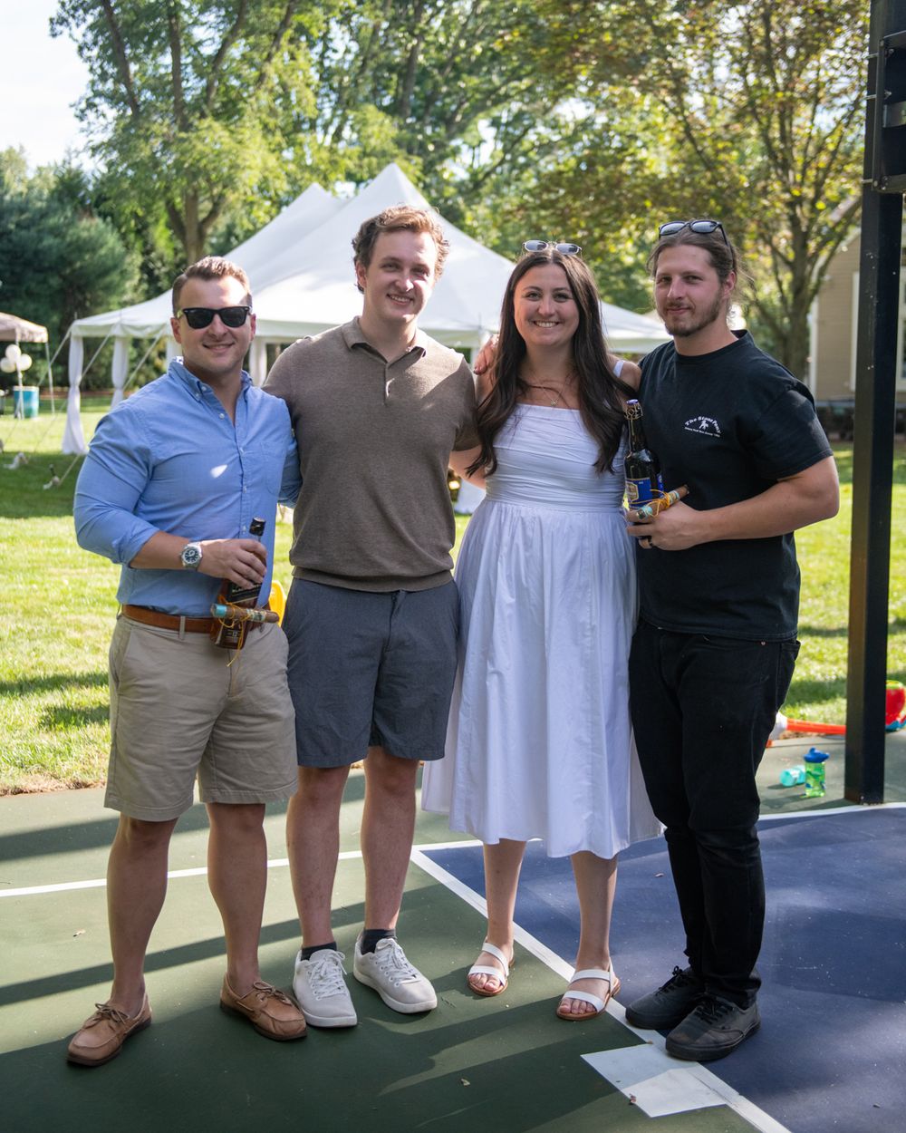 Group photo at an outdoor summer gathering with drinks on a sunny day.