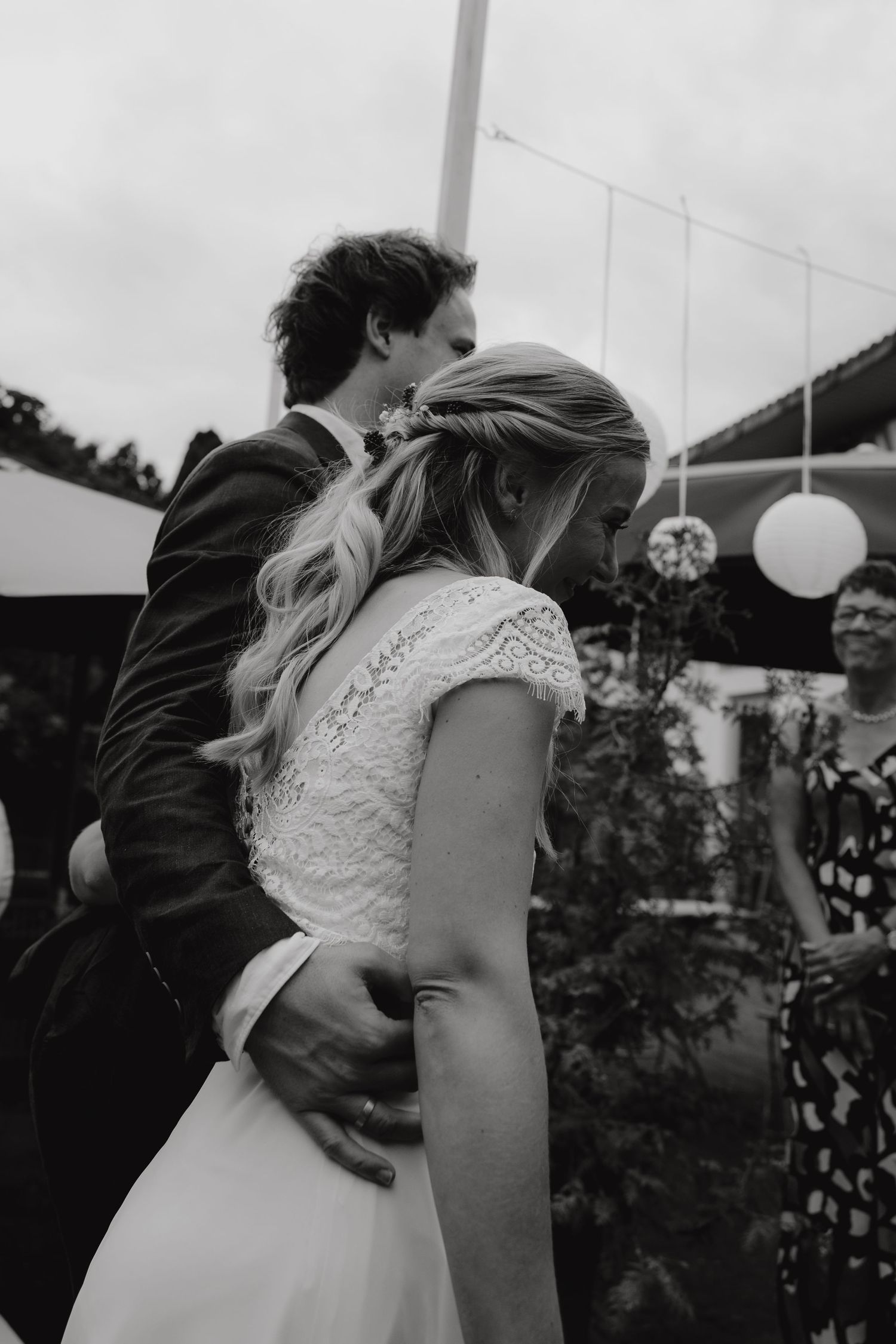 A romantic black and white moment between newlyweds with paper lanterns in the background.