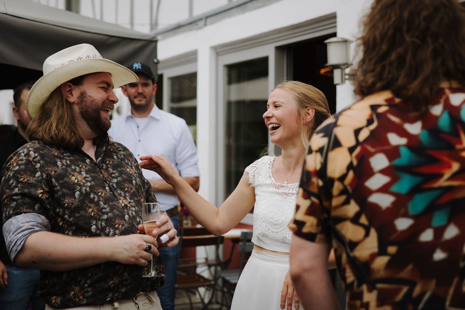 Wedding guests sharing laughter and joy during an outdoor reception celebration.