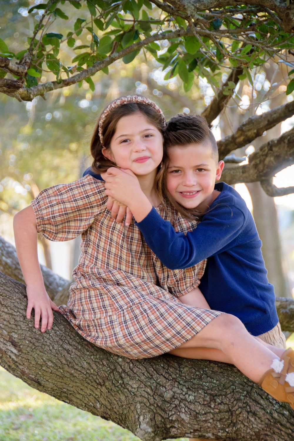 photo of brother and sister hugging on tree branch in New Port Richey