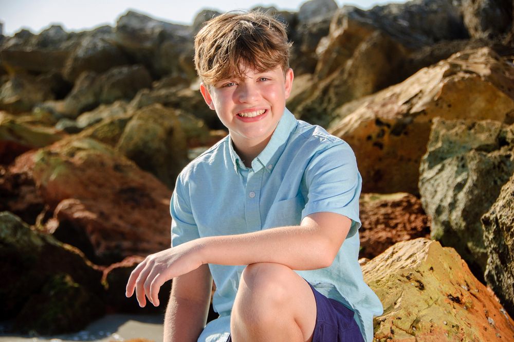 photo of teenage boy sitting in rocks in New Port Richey