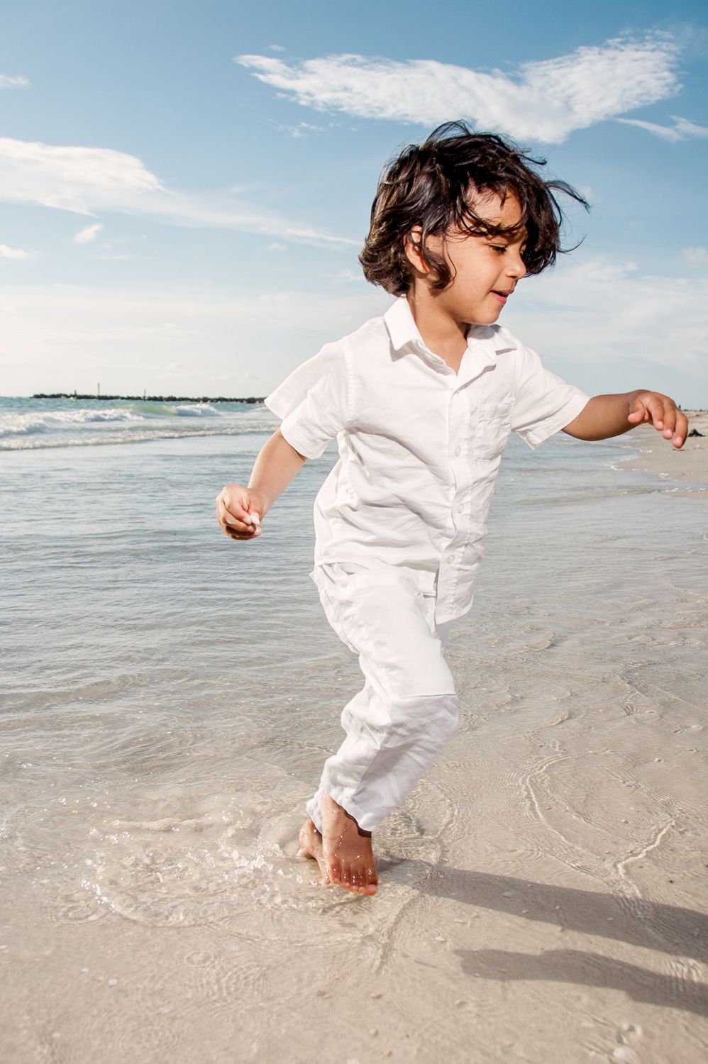 photo of boy in white running on beach in New Port Richey