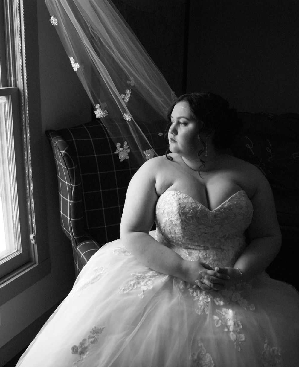 Dramatic black and white bridal portrait with natural window lighting.