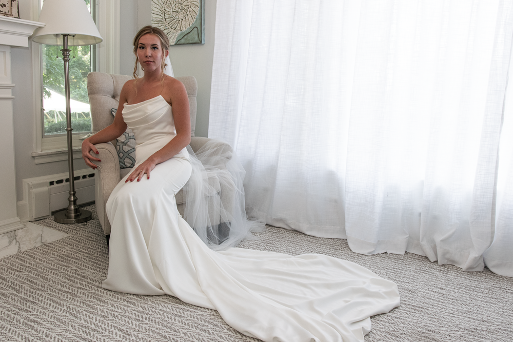 Bridal preparation photos in an elegant white room with flowing curtains.