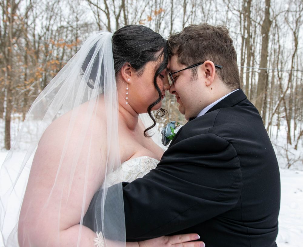Winter wedding couple portraits in a snow-covered forest setting.