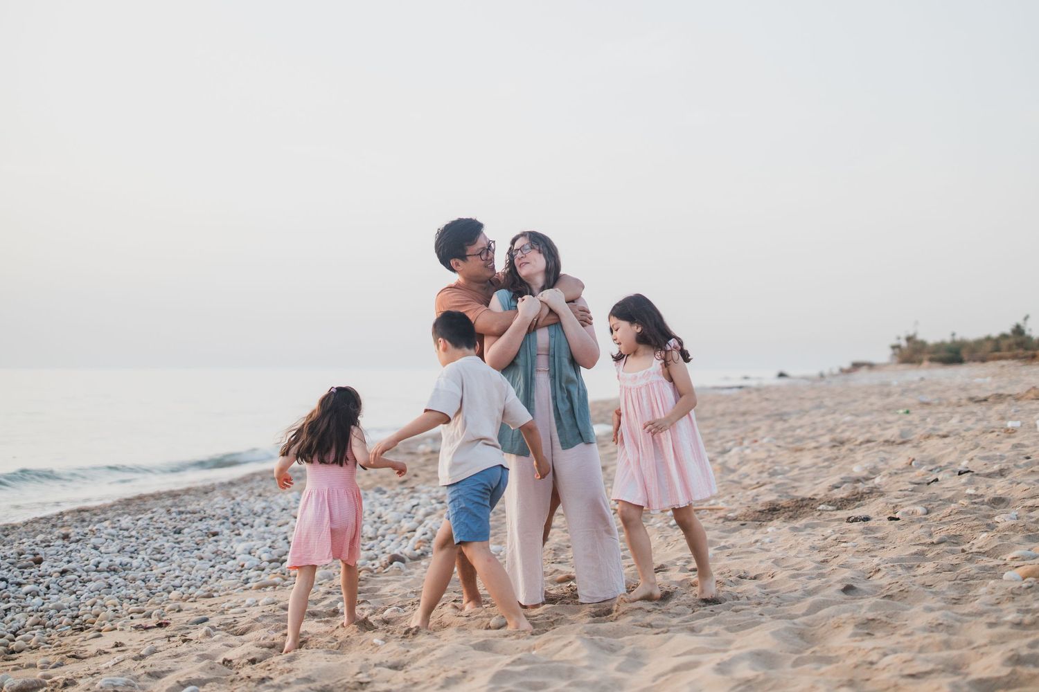 Family enjoying a playful moment together on a sandy beach.