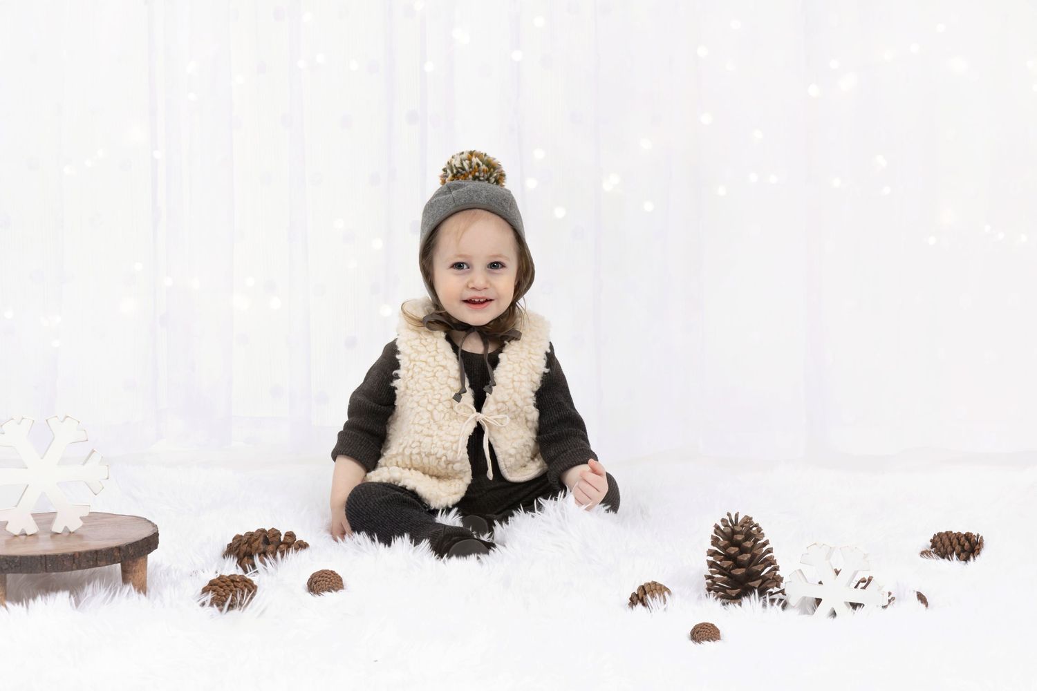 A winter portrait scene with snow and pinecones as natural props.