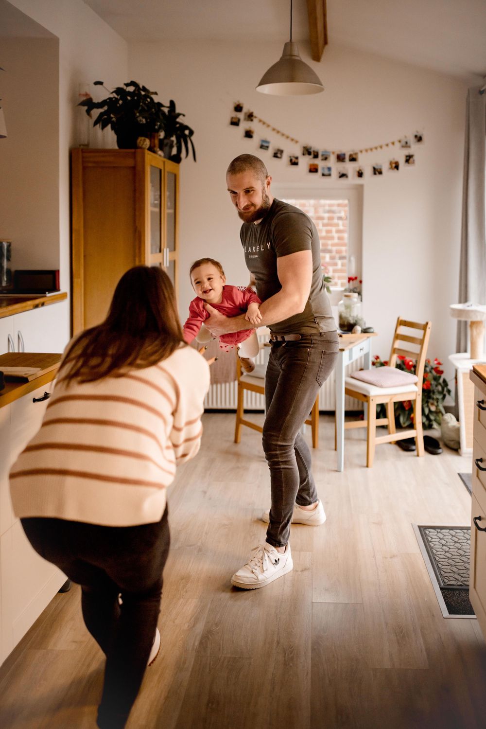 A casual family scene in a modern kitchen with natural lighting.