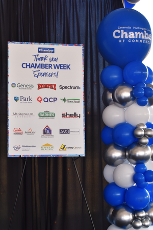 Event backdrop display with blue and silver balloon arrangements featuring sponsor logos for Chamber Week.