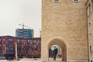 Stone archway framing modern colorful building construction in the background. Tirana, Albania,
