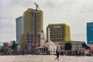 Urban plaza with modern high-rise construction and historic building in foreground. Tirana, Albania,