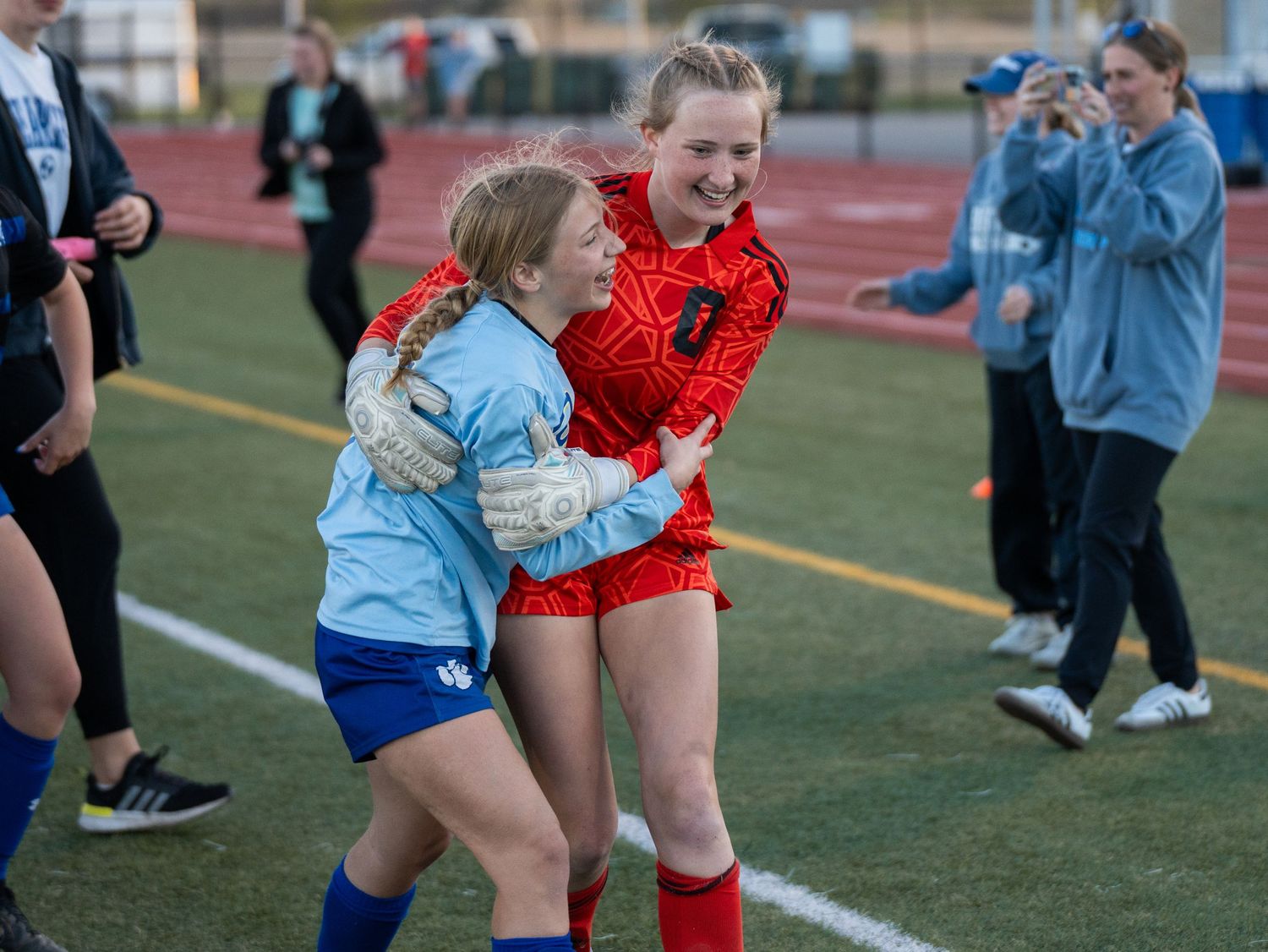 Athletes share emotional celebration moment after soccer match.