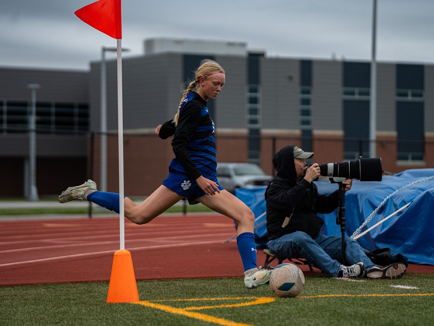 Player jumps past orange cone marker during soccer practice drill.