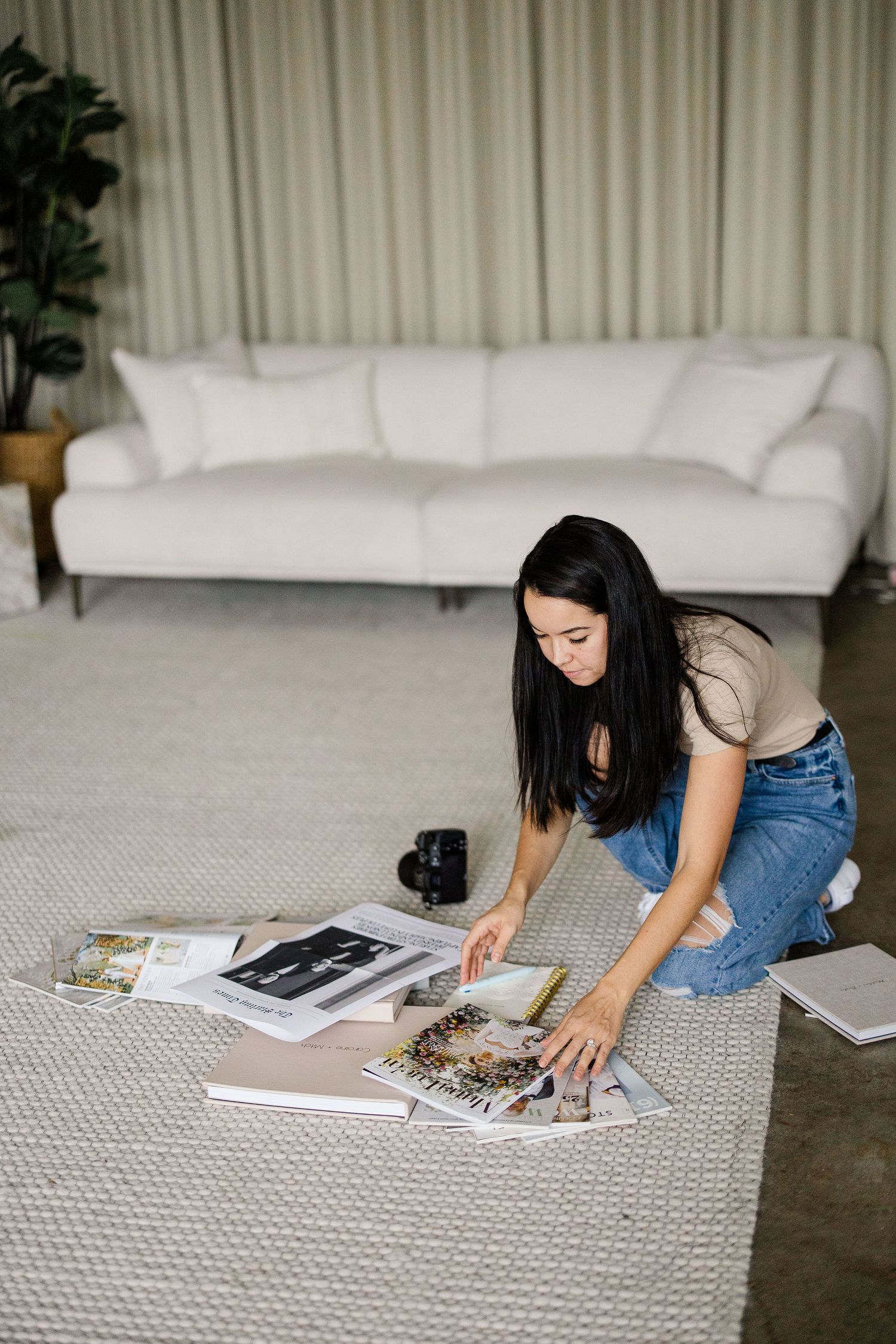 Person flips through pages of photo albums while sitting on carpeted floor.