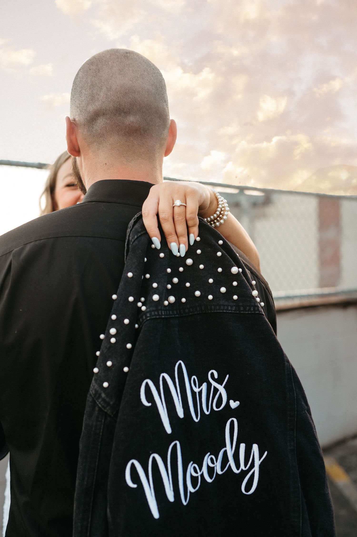 Custom denim jacket with Mrs. Moody embroidery shown at sunset.