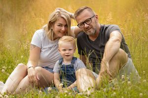 Family members relax together in a golden summer meadow during sunset.