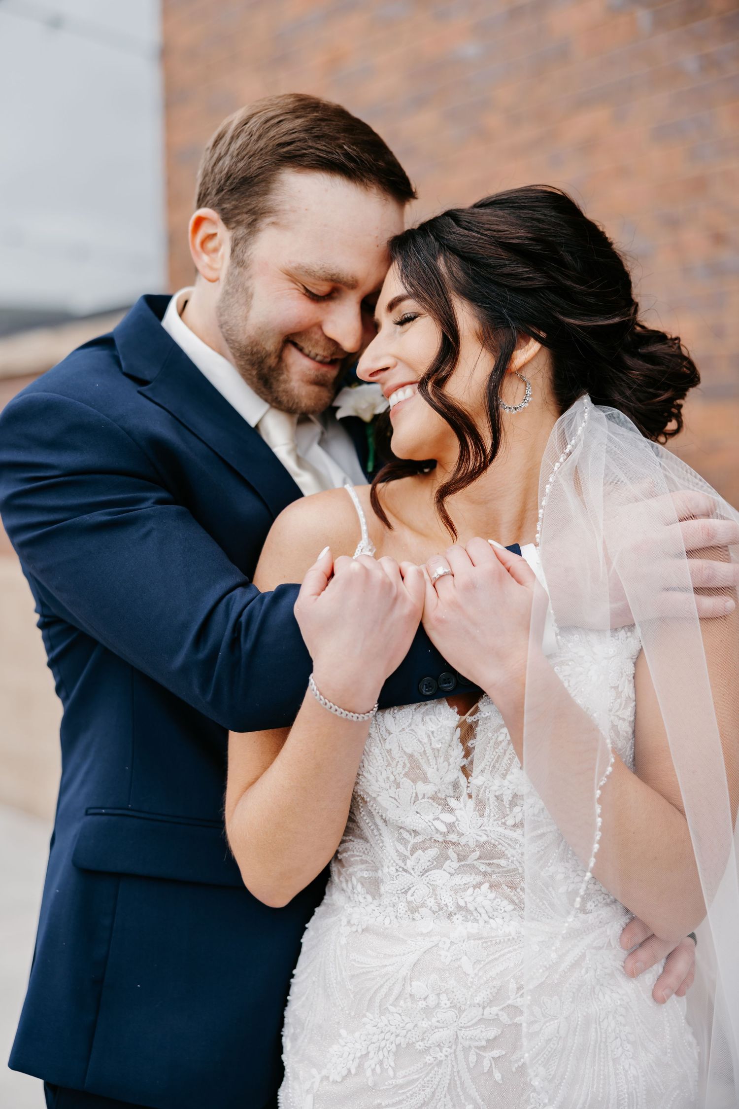 Groom kissing bride on the forehead during an apple orchard wedding