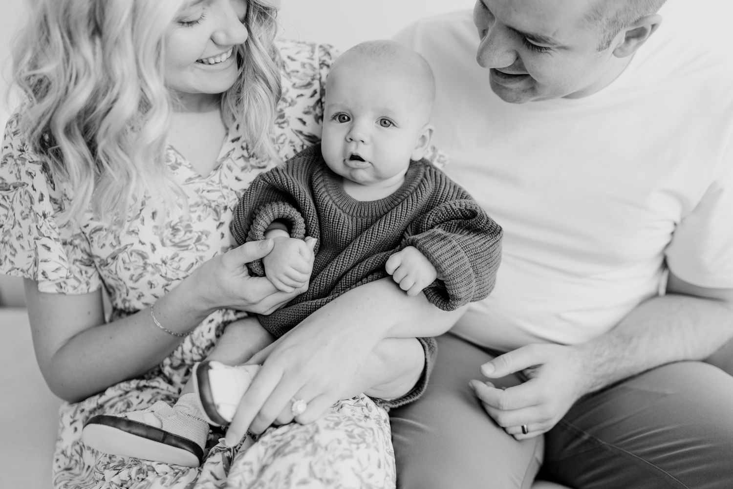 Black and white family portrait showing tender moments with young child.