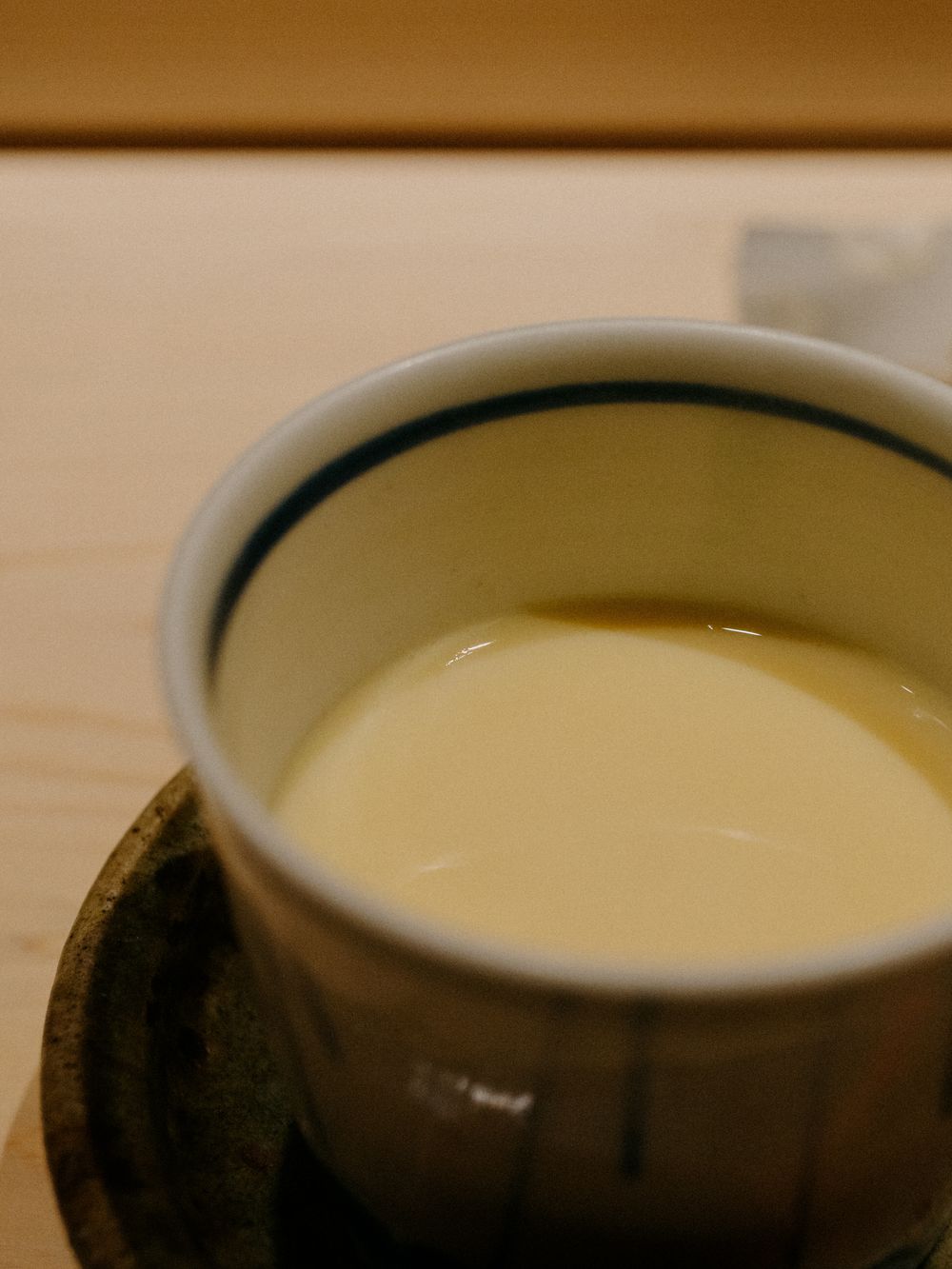 A cup of creamy green tea or matcha served in a traditional ceramic cup.