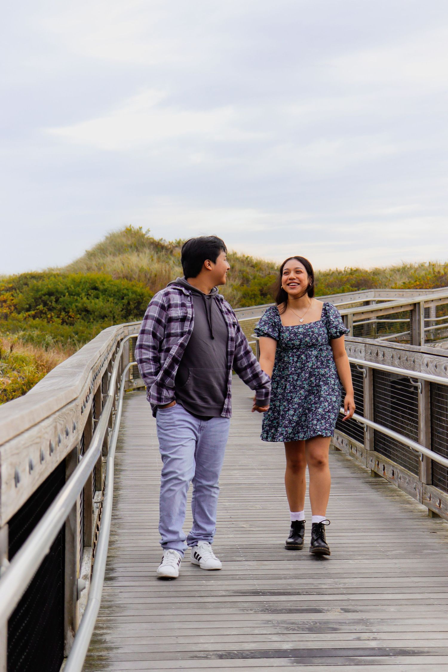Couple enjoying conversation while walking on elevated wooden boardwalk.