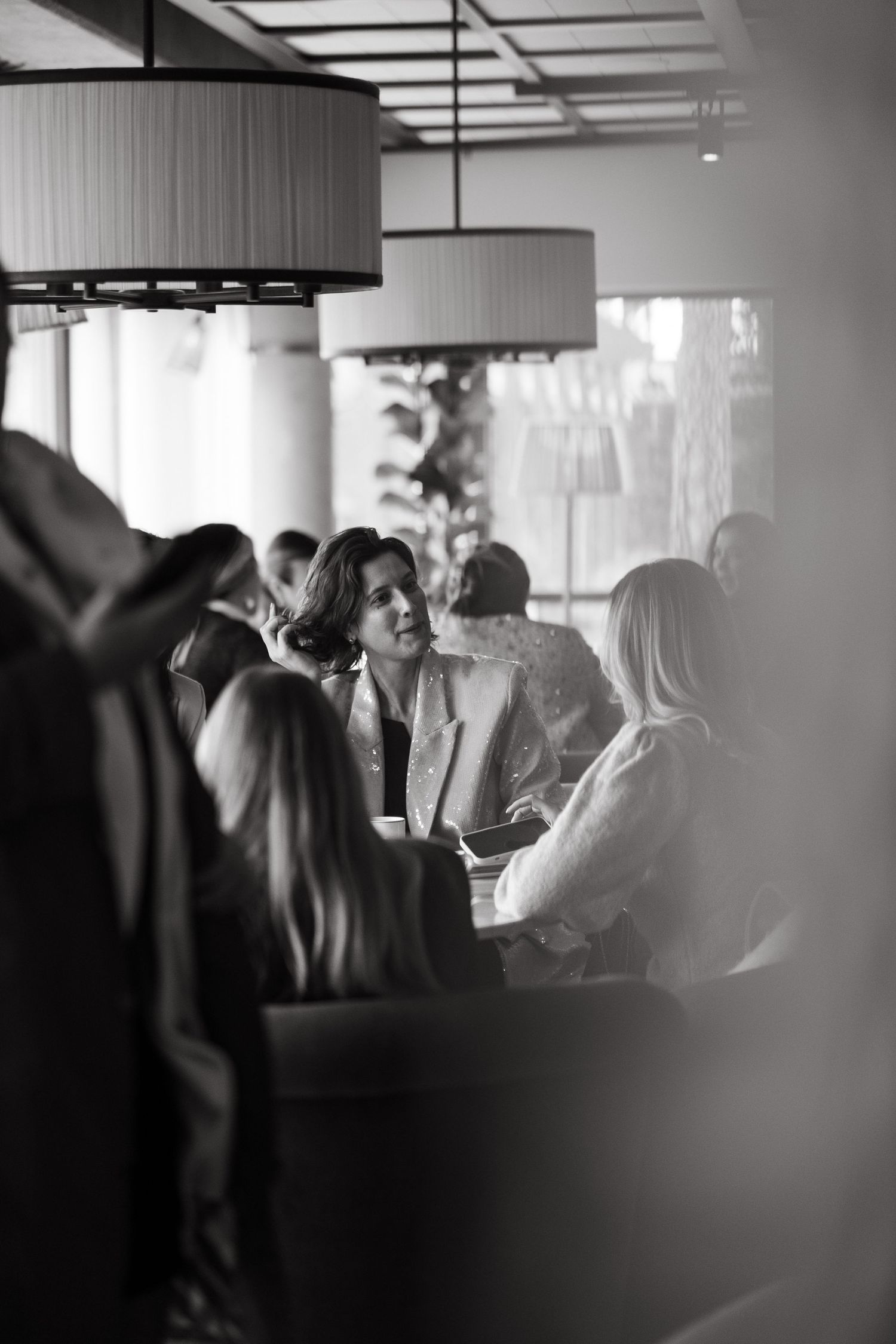 women sitting at table during lunch interacting while being captured by event photographer in Stockholm