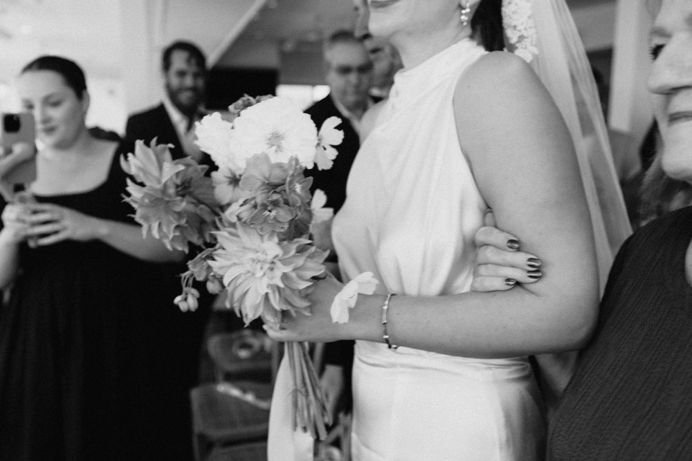 “Intimate wedding ceremony on a rainy day at Noosa Boathouse, captured by a documentary-style photographer