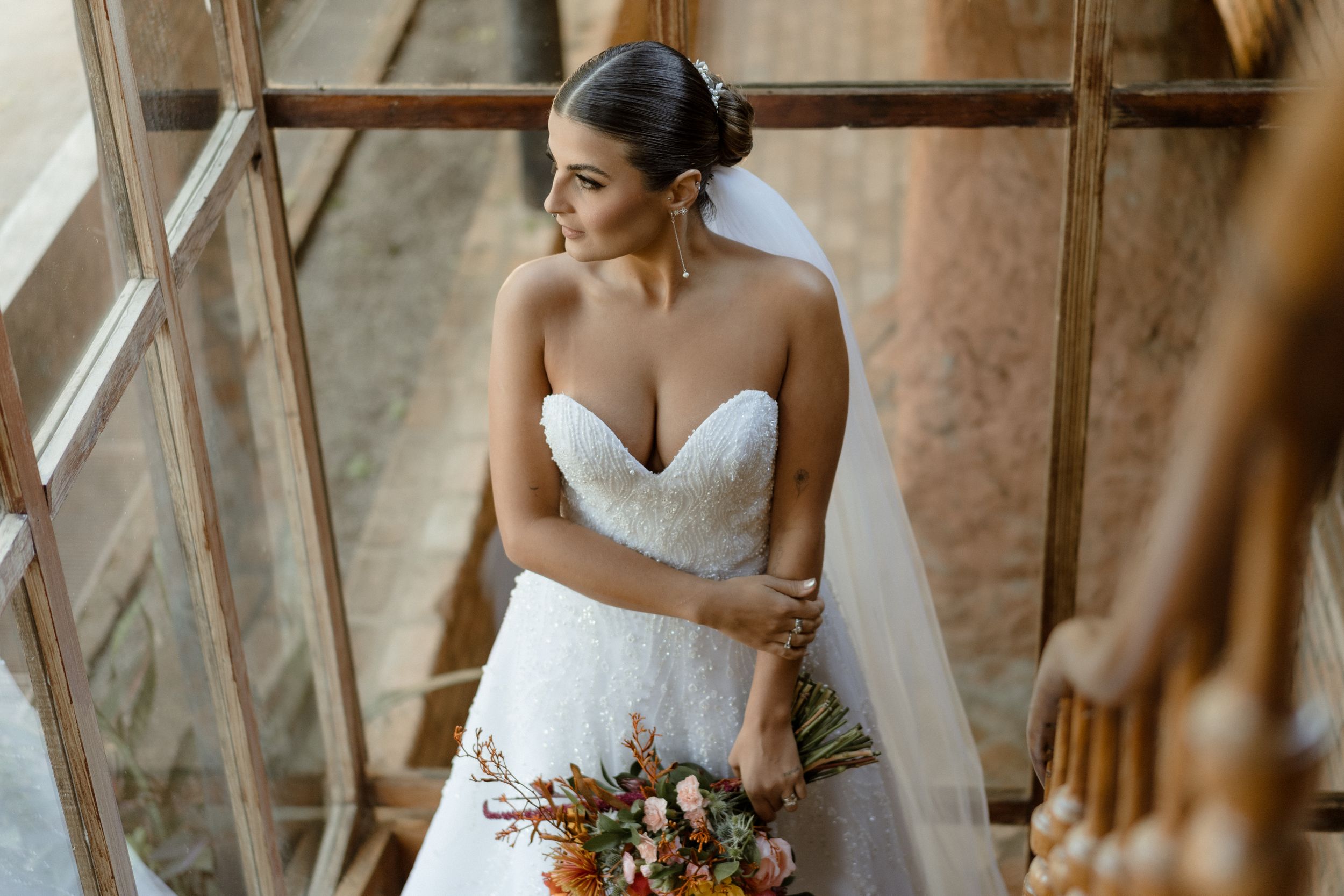 Elegant bridal portrait showcasing strapless gown and fall floral arrangement.