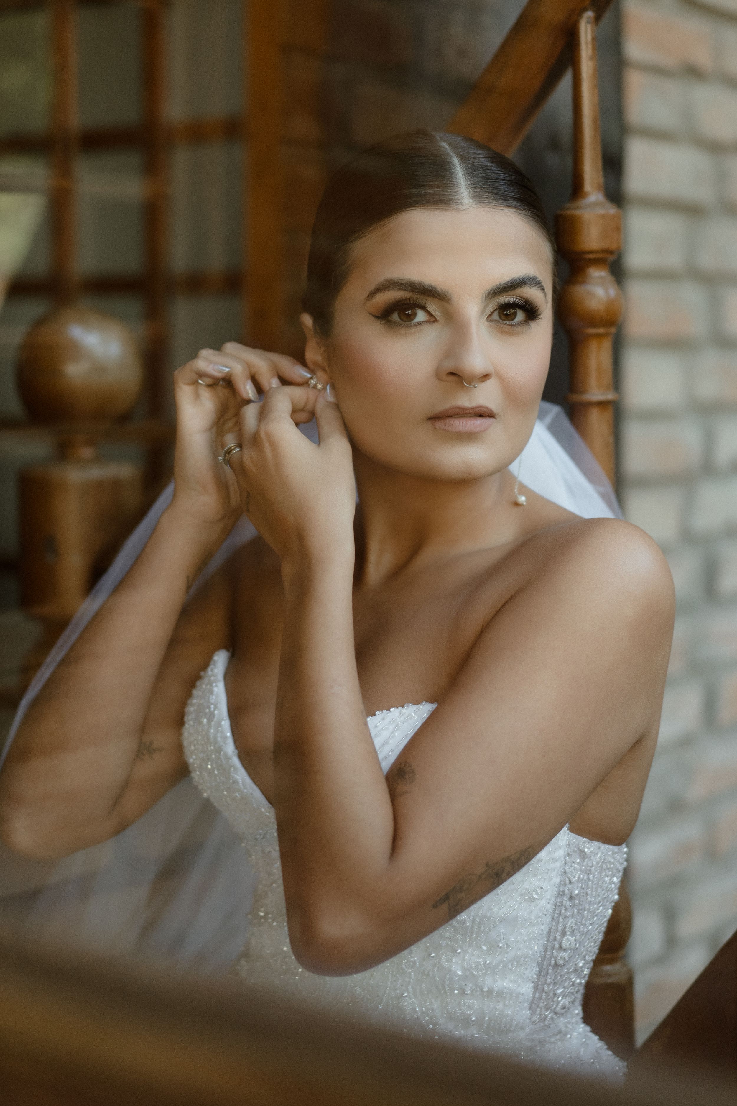 Intimate bridal portrait against exposed brick with natural window lighting.