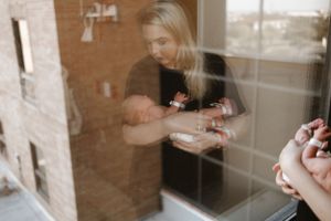 Blurred reflection of mother and newborn through window glass.
