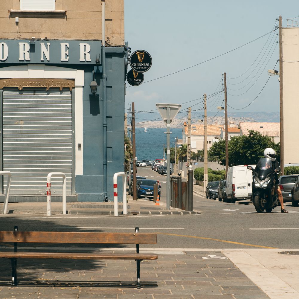 Empty street corner with vintage diner and benches in urban setting.