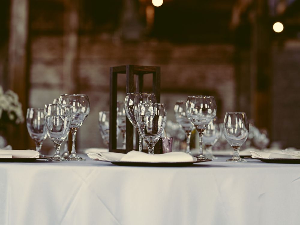 Elegant table setting with wine glasses and lantern centerpiece at wedding reception.