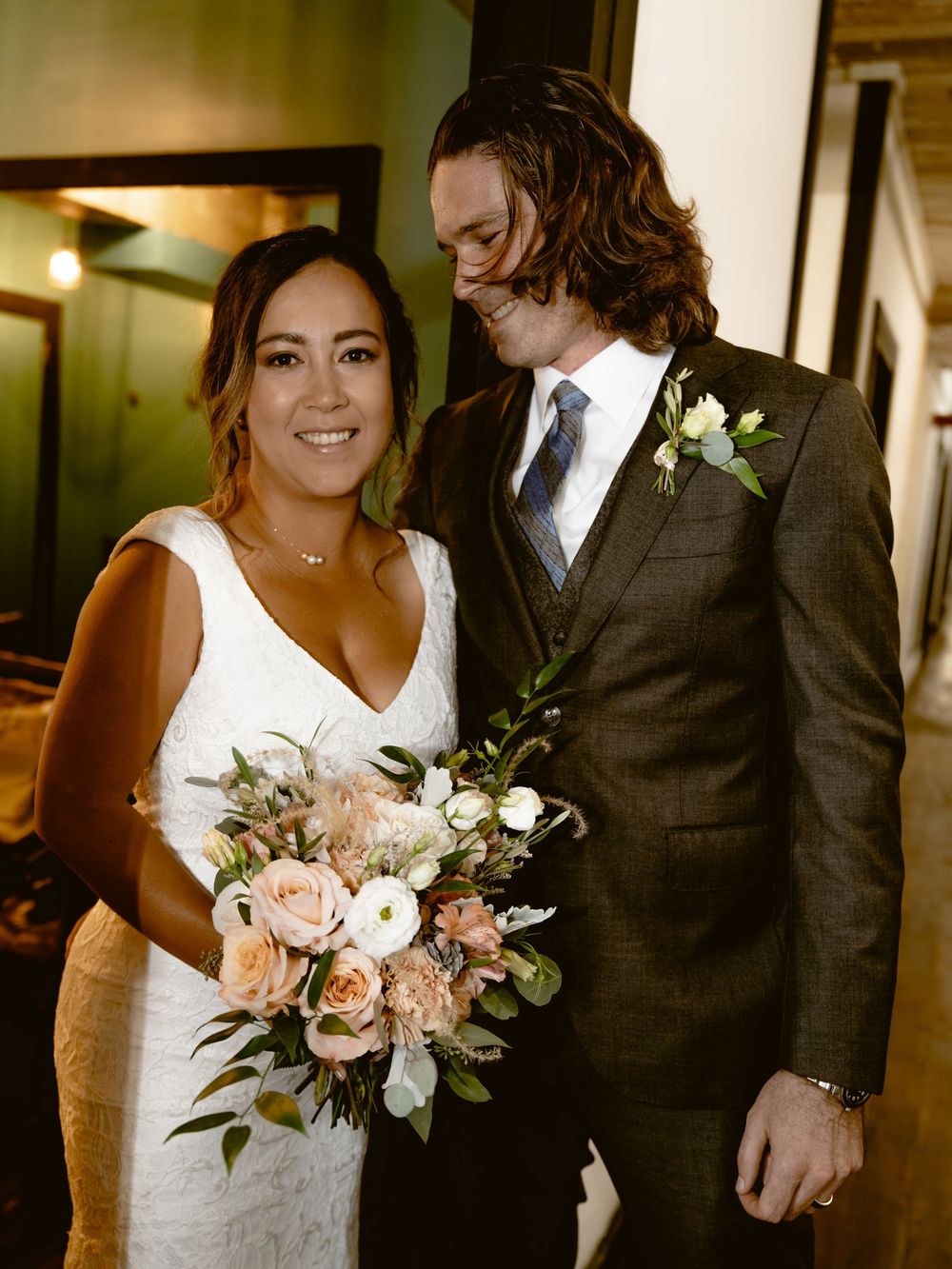 Elegant wedding portrait featuring beautiful bouquet with pink roses and white flowers.