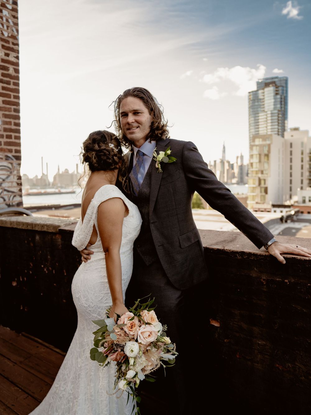 A romantic rooftop wedding portrait with the New York City skyline in the background.