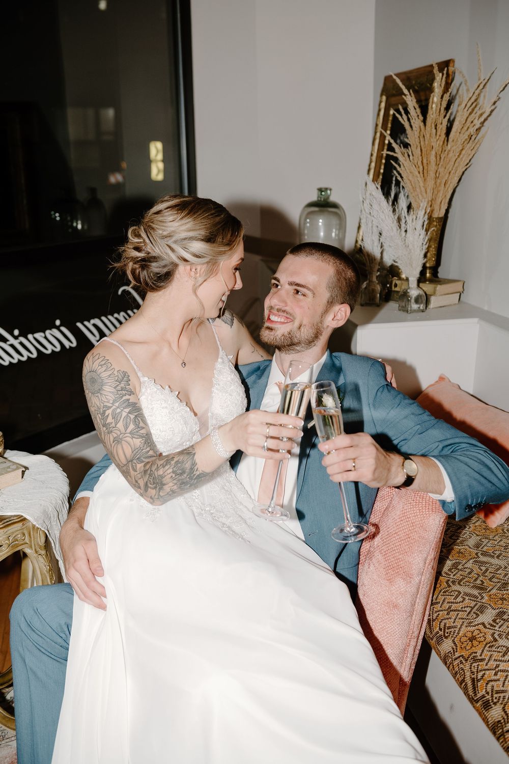 A couple in wedding attire shares intimate moments while enjoying champagne in a sequence of candid reception photos.
