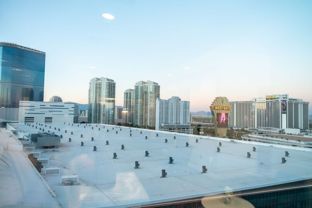Aerial view of Las Vegas cityscape with rooftop ice rink and high-rise buildings against blue sky.