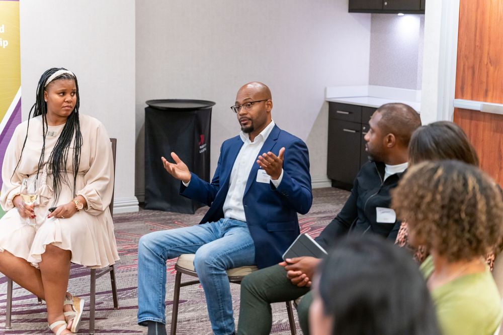 A group of professionals engaged in an animated discussion during a business meeting in a modern office setting.