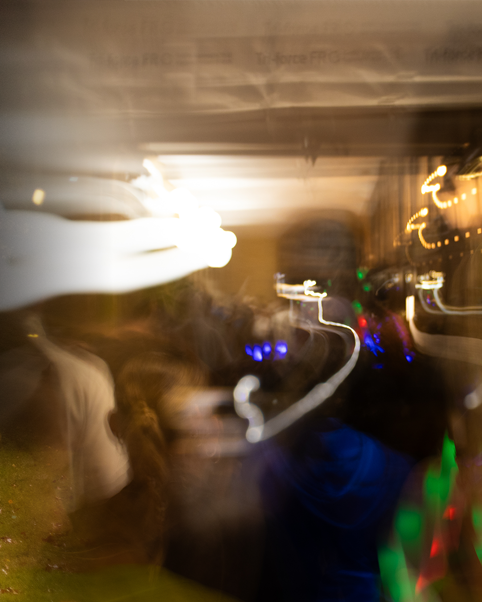 Abstract long exposure photograph showing blurred motion and colourful light trails in dark setting.