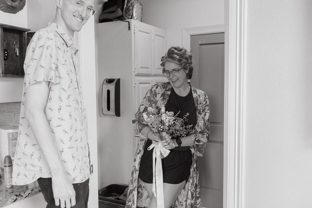 Vintage black and white photograph showing two people standing in a doorway wearing patterned clothing.
