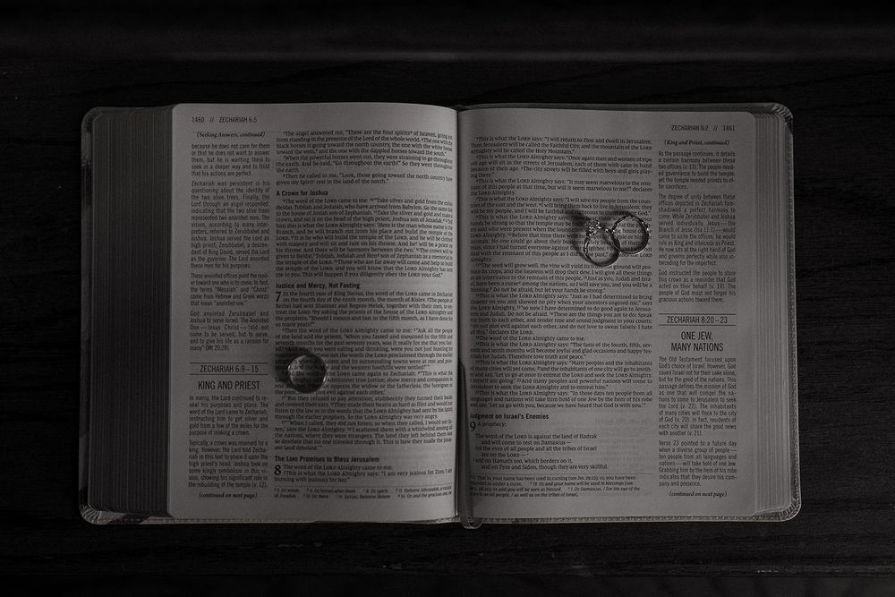 Several open textbooks or manuals shown in dark lighting conditions displaying text and diagrams on their pages.